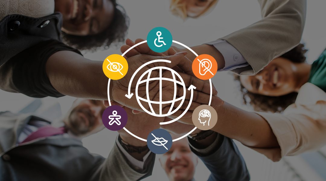 Diverse group of adults placing hands on top of each other in a circle.