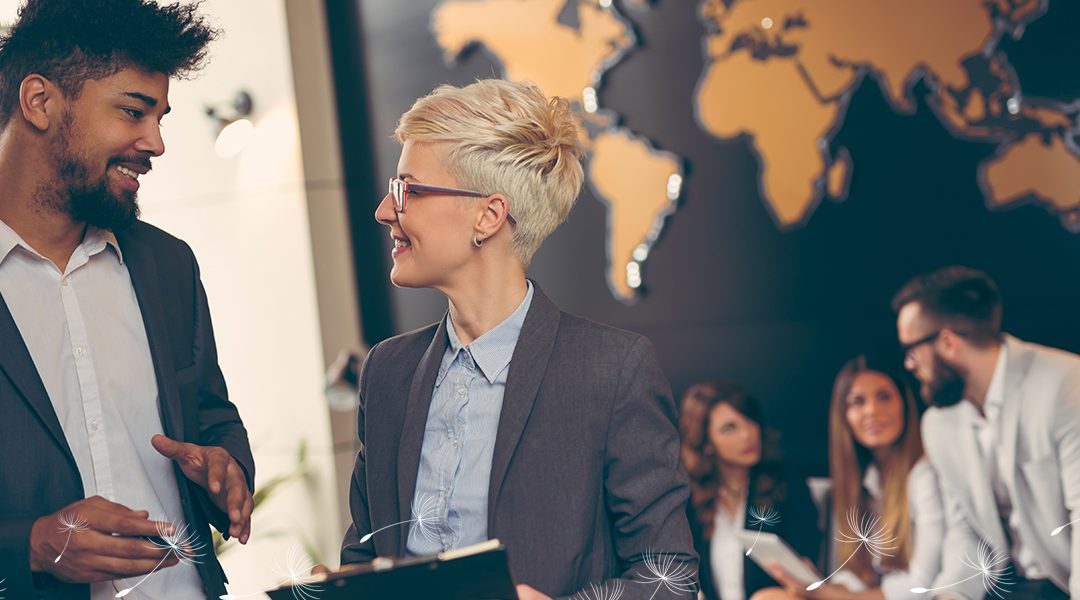 Male and female discussing business in front of a map of the world