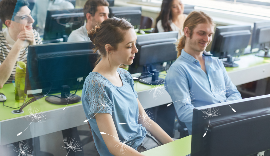 Neurodiverse students sitting in a computer lab listening to their instructor.