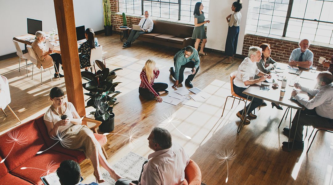 Diverse group collaborating in a bright, open office with dandelion seed graphics symbolizing inclusion and growth.